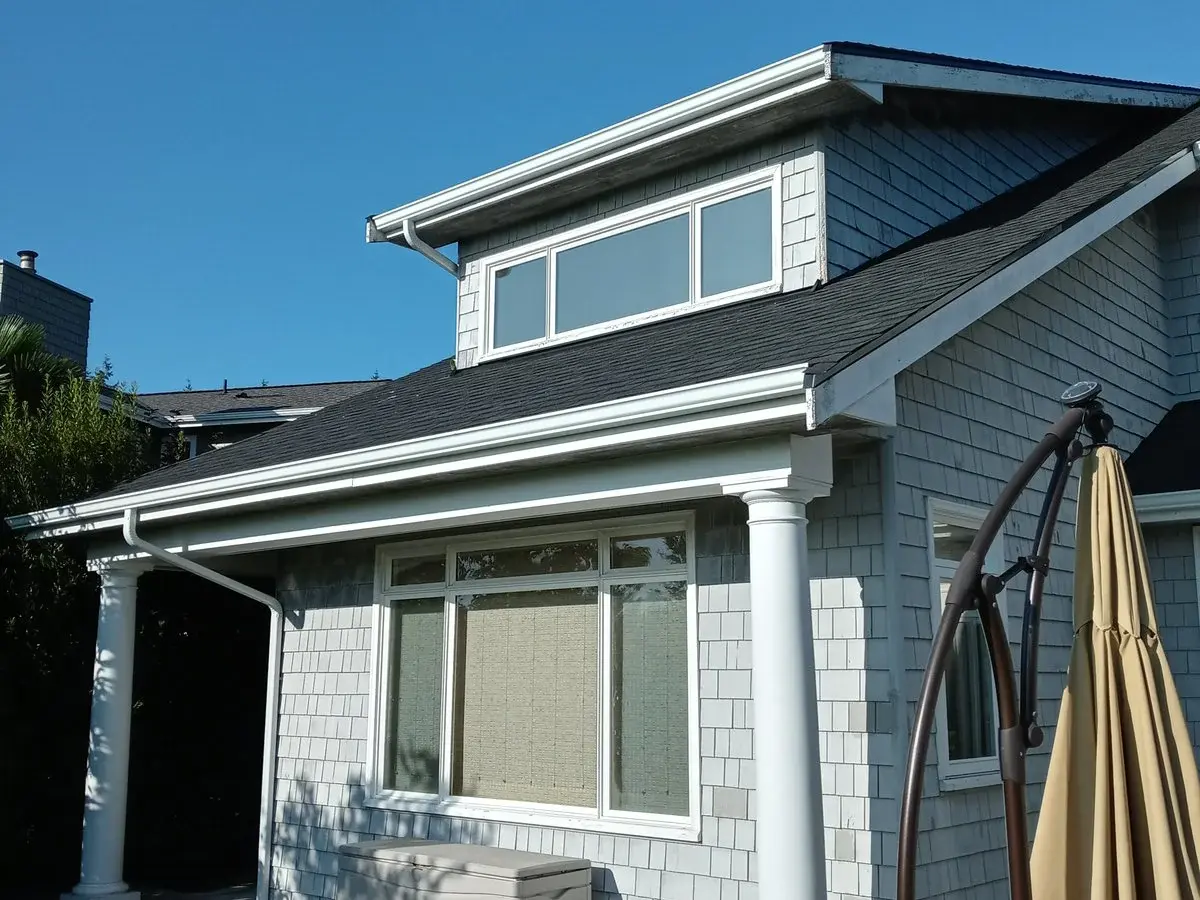 New white gutters on a blue house